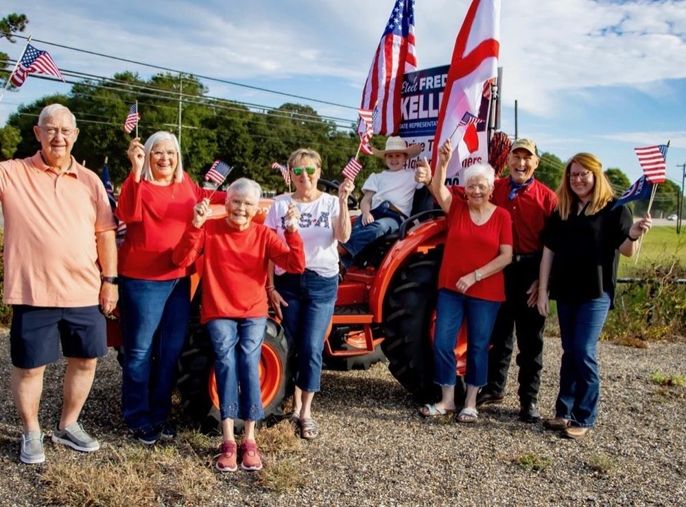 Supporters with American and Alabama flags beside a tractor